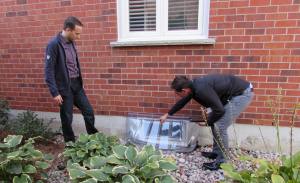 Home Assessor points to window well cover during home flood protection assessment