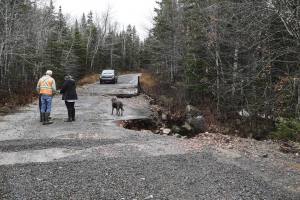 Damaged Road with car and people standing