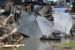 people in raft in front of collapsed building