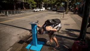 Man pours water over his head in street during heat wave