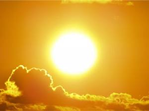 Orange Sun in sky with clouds